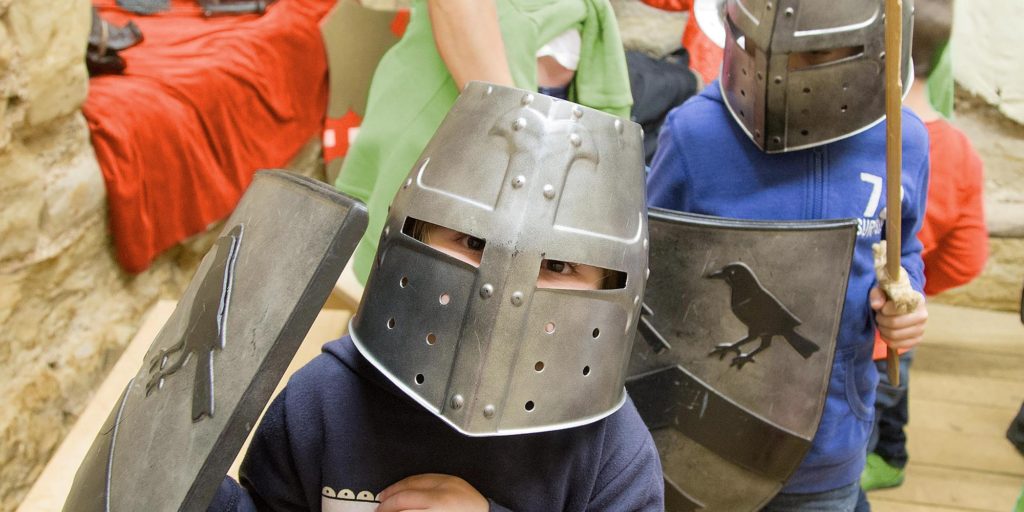 Kids in knights outfits at a castle