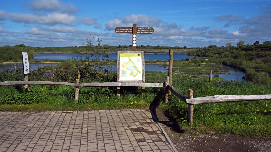 Lake, map and signpost for paths.