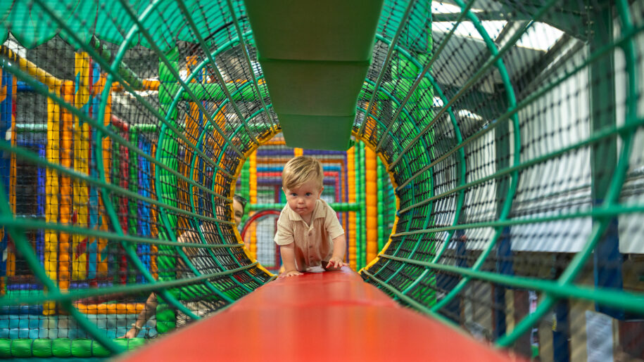 child crawling through play tunnel