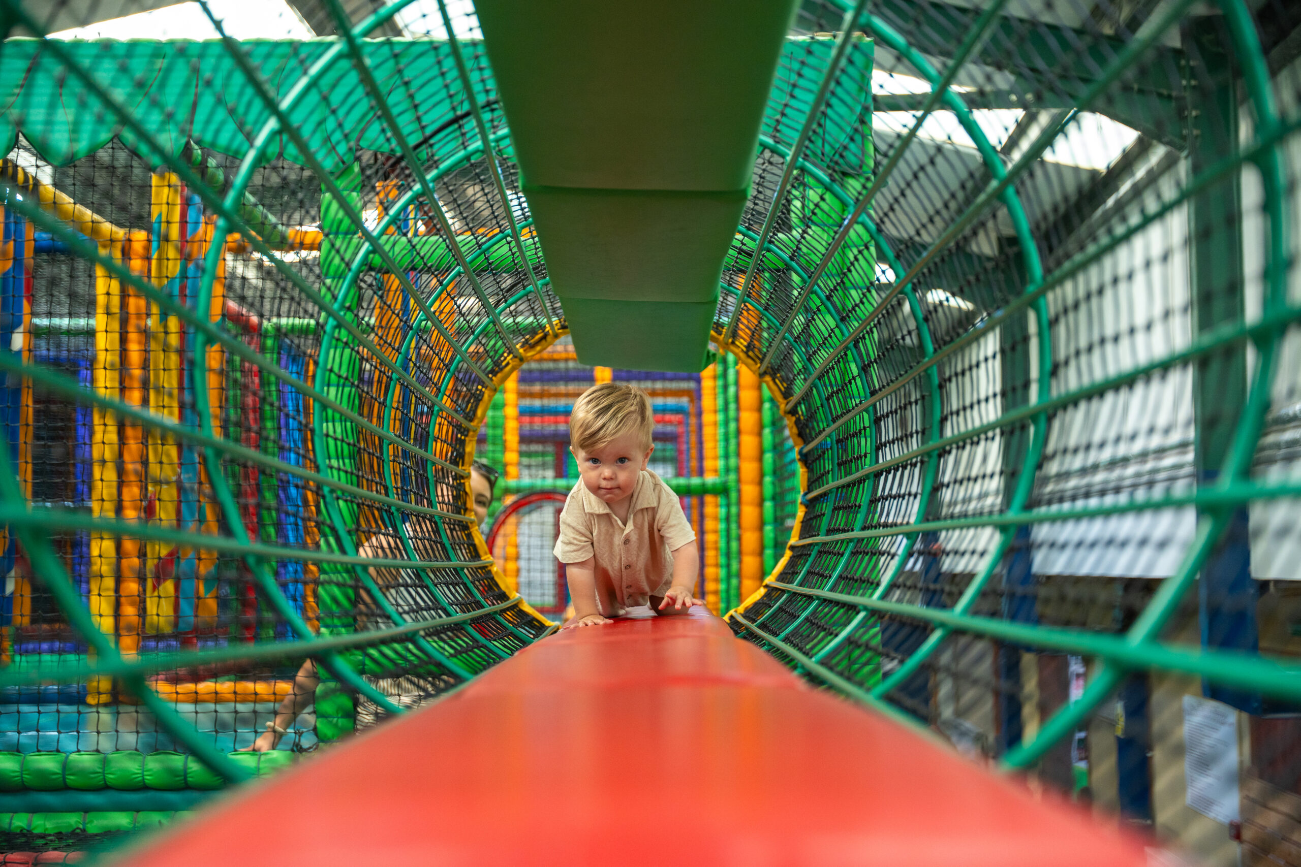 child crawling through play tunnel