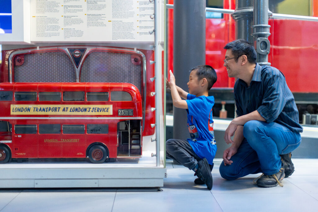 boy and dad look at model of bus