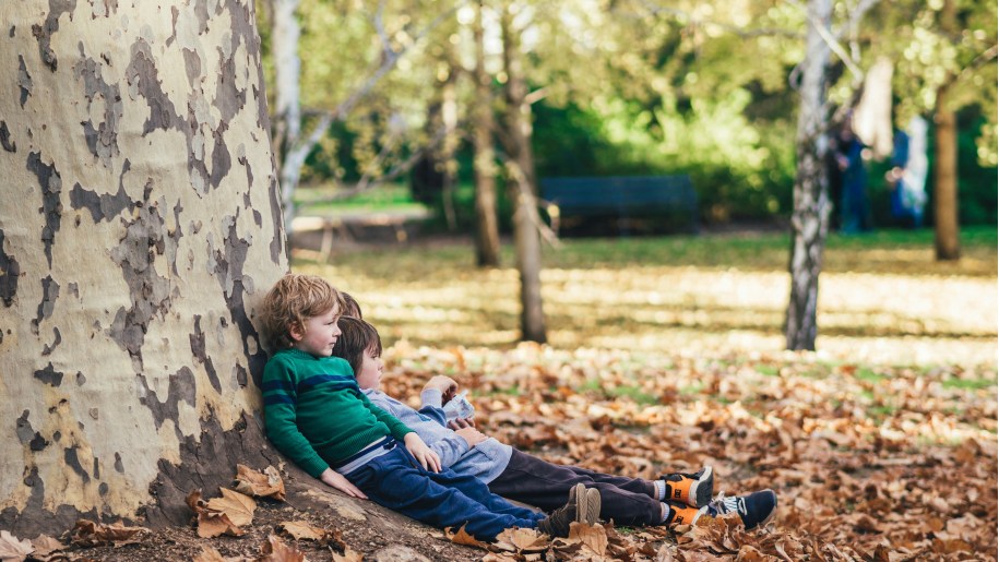 Children sitting under a tree.