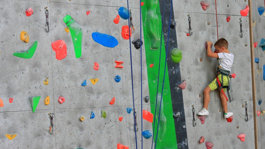 Child climbing on indoor climbing wall.