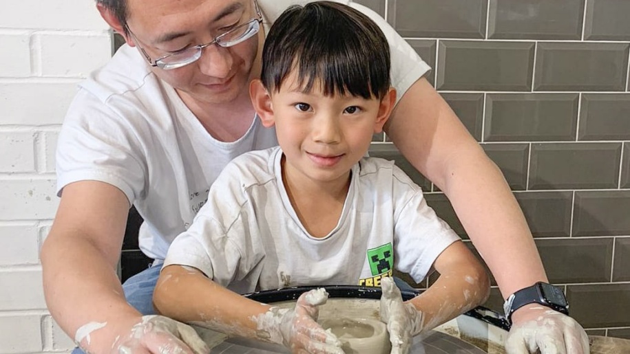 Father and son at a potter's wheel at Honeybourne Pottery.