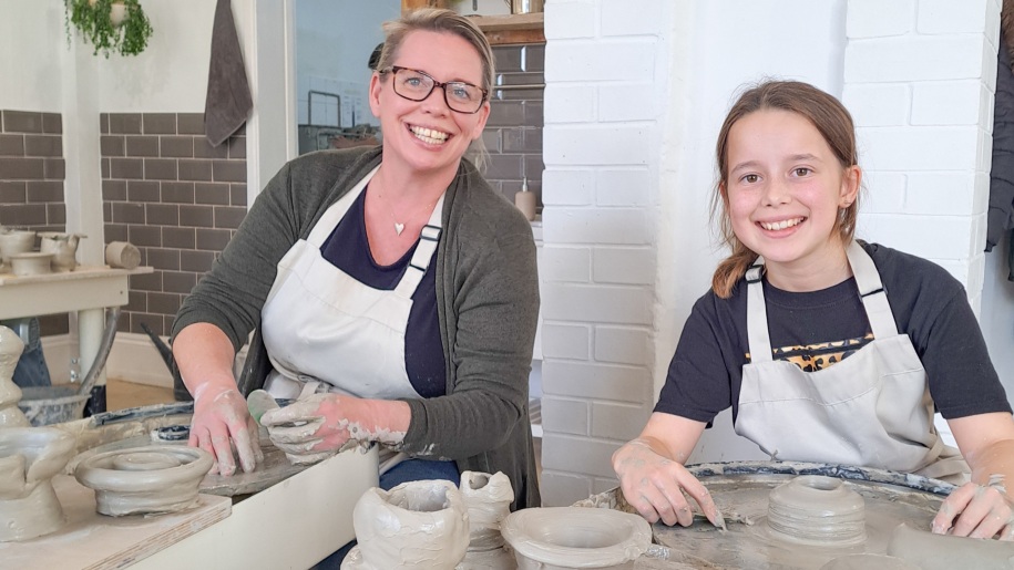 Mother and daughter at a potter's wheel at Honeybourne Pottery.