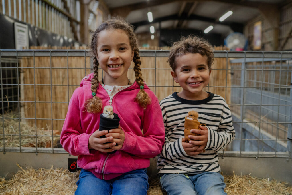 two children hold farm animals