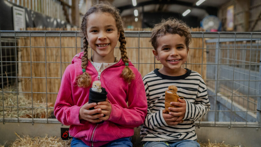 two children hold farm animals