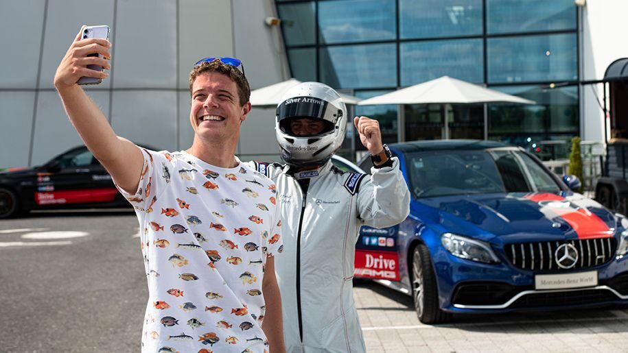 Man having a selfie with racer at Mercedes-Benz World
