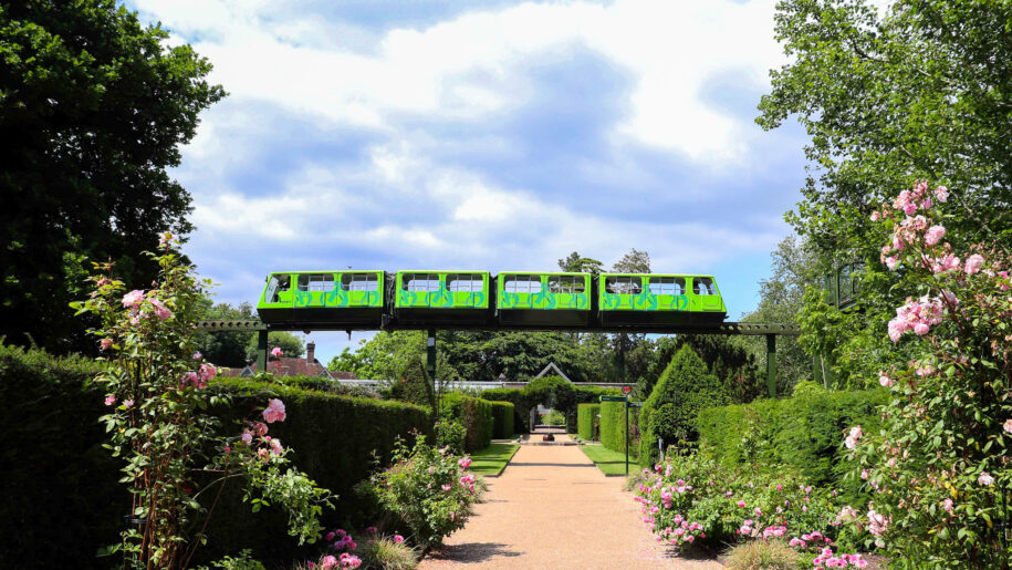 green monorail goes over a garden