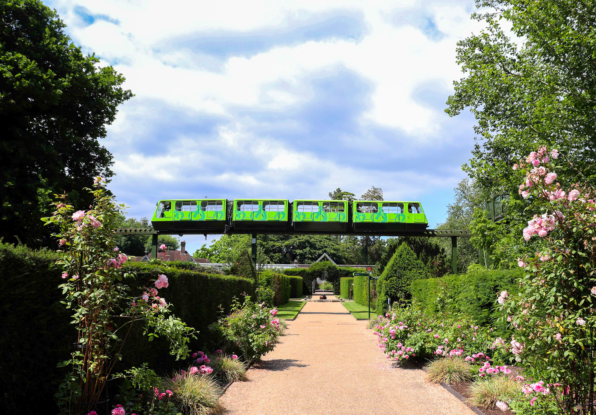 green monorail goes over a garden