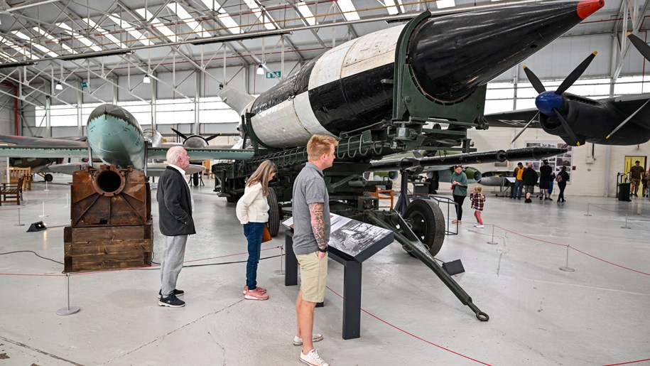 Visitors looking at displays in a hangar at the Royal Air Force Museum Midlands.