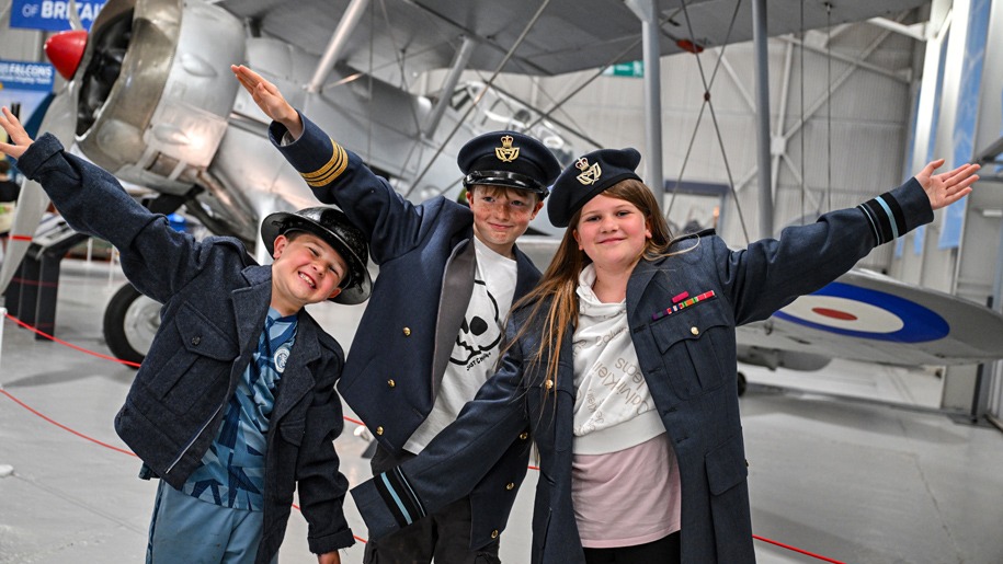 Children dressing up in uniform at the Royal Air Force Museum Midlands.