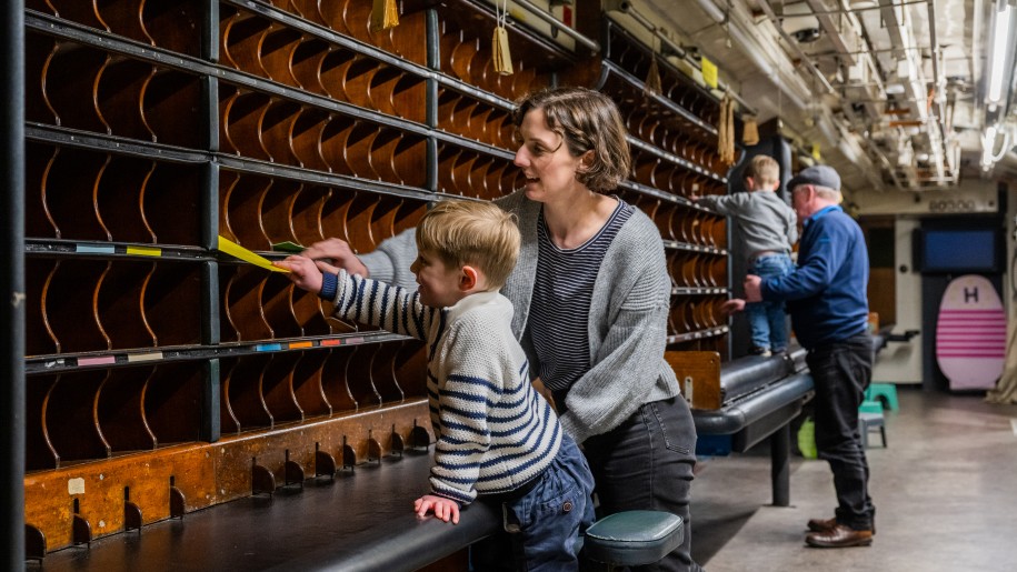 Adult and child sorting letters in the Travelling Post Office at the Severn Valley Railway.