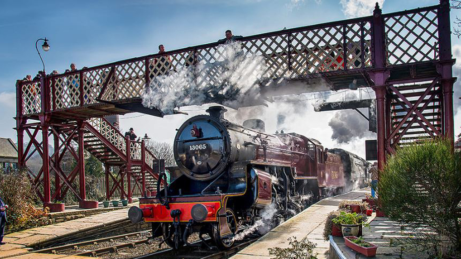 steam train going under bridge