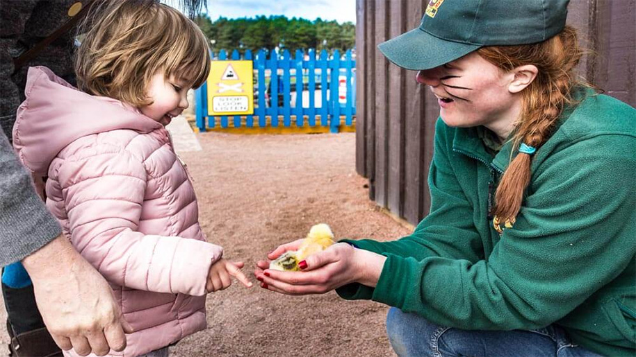 women showing a girl a chick