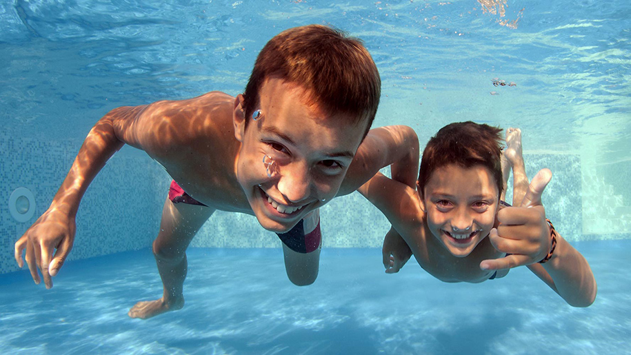 two boys swimming under water