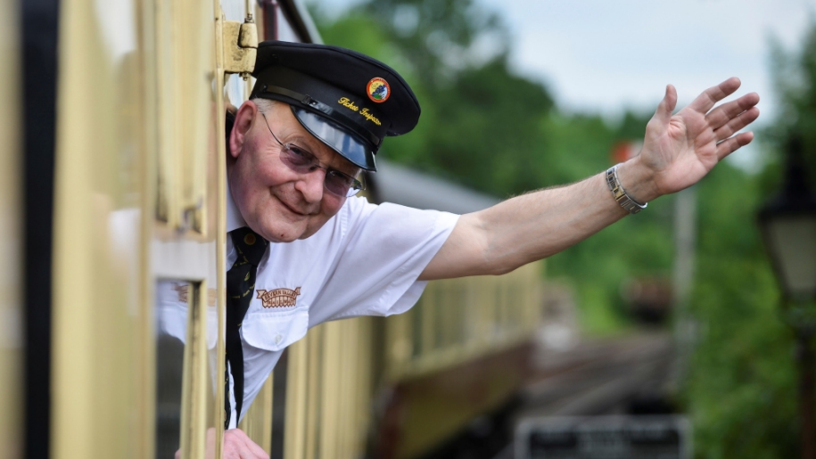 Train conductor waving out of train window