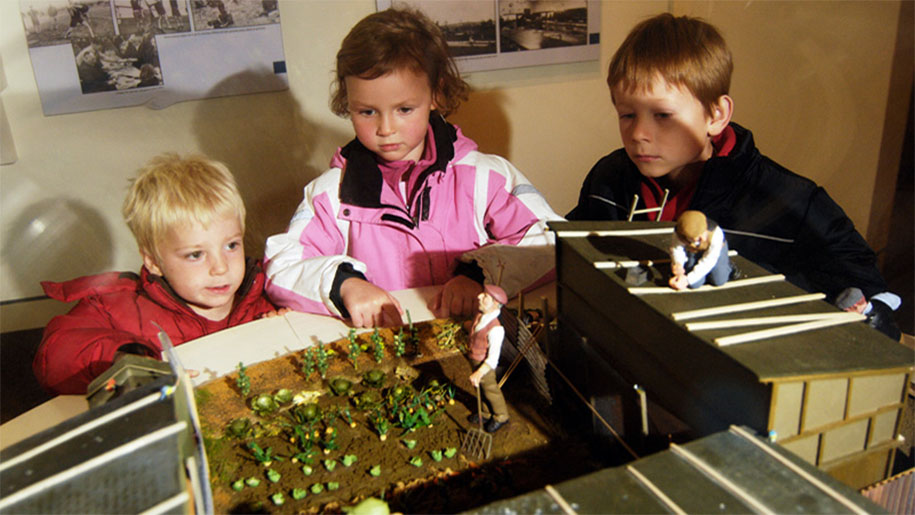 children looking at model of farmers