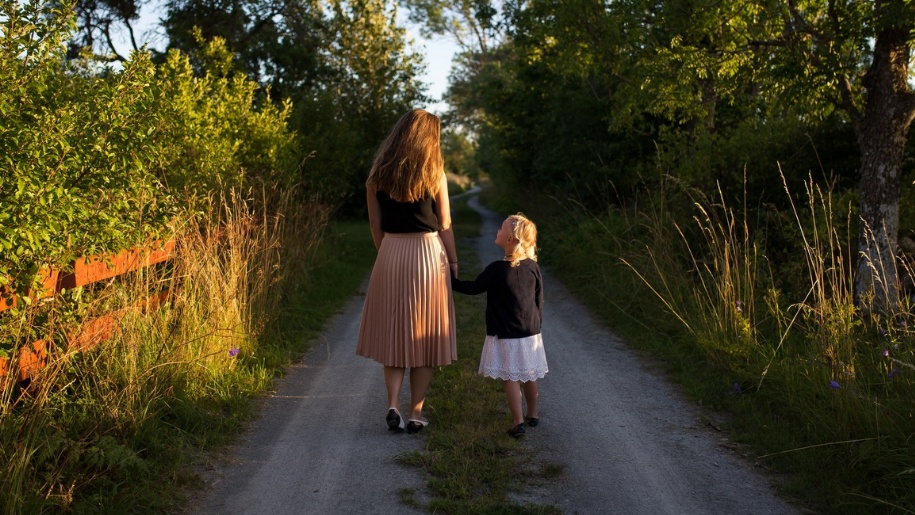 Mother and child walking down a country lane.