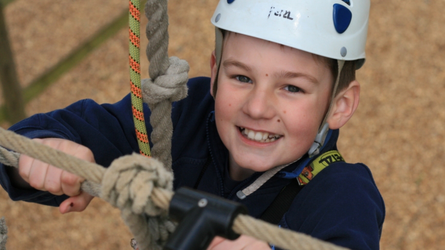 boy climbing on high ropes