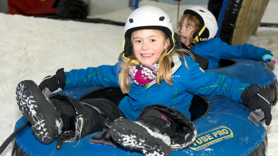 Two children in donuts on ski slope