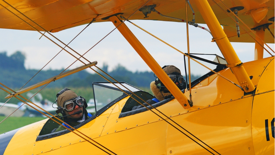Pilots in a vintage aeroplane.