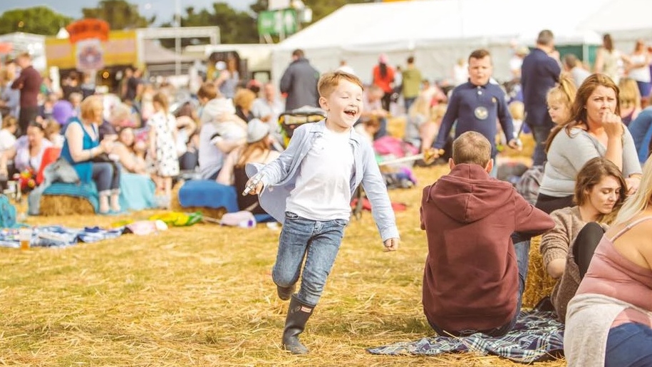 child running around and parents on picnic blankets