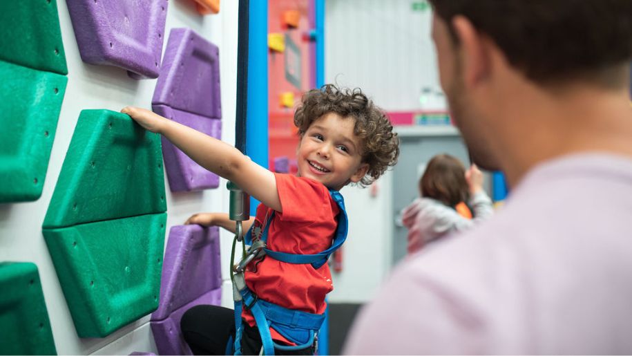Young boy climbing the indoor climbing wall at Jump In Aberdeen