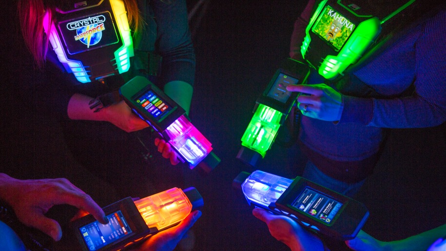 Players' hands holding laser guns for Laser Force games.