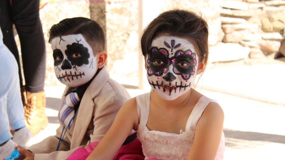 Two children with their faces painted for Halloween.