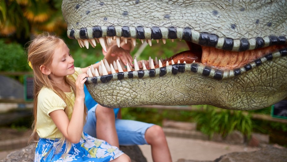 girl looking in dinosaur mouth at Wookey Hole
