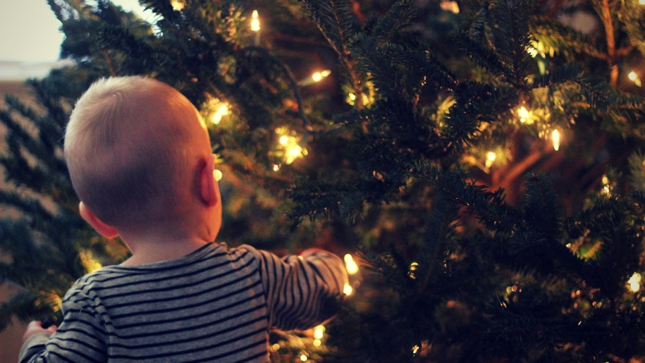 toddler hanging up christmas decorations