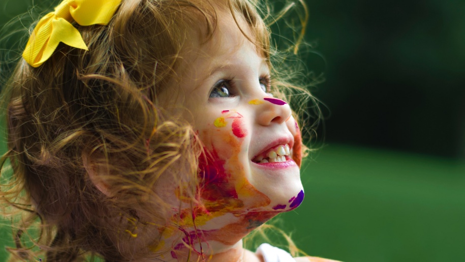 Toddler with paint on face.