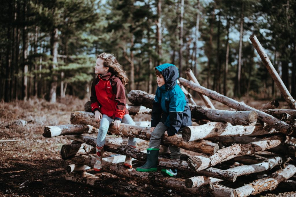 kids sitting on log pile