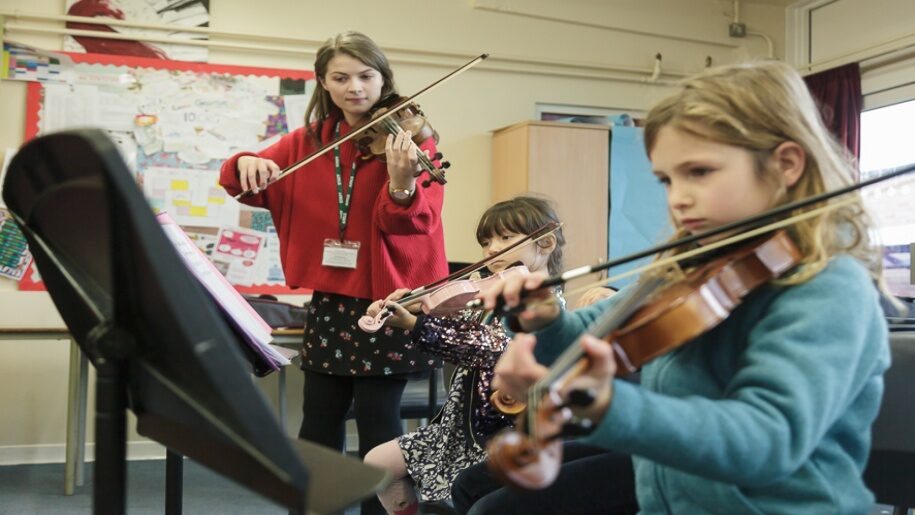 Saffron Centre for Young Musicians - Saffron Walden - Three girls playing violins and reading sheet music