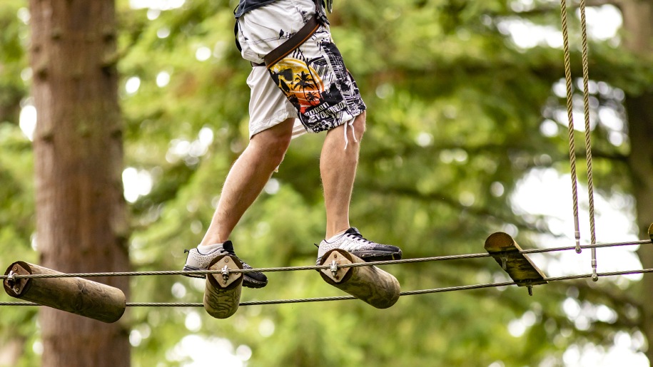 View of visitor's legs on high-level crossing at Go Ape