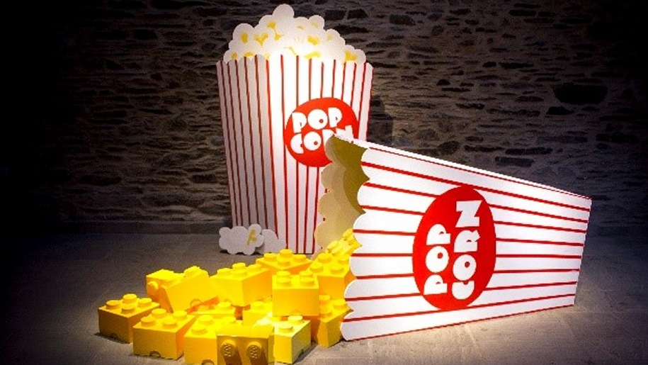 Small yellow LEGO® bricks pouring out of popcorn container