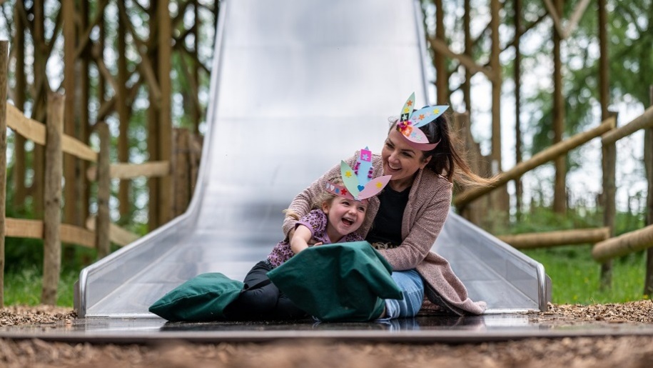 mum and young girl on slide at BeWILDerwood Cheshire