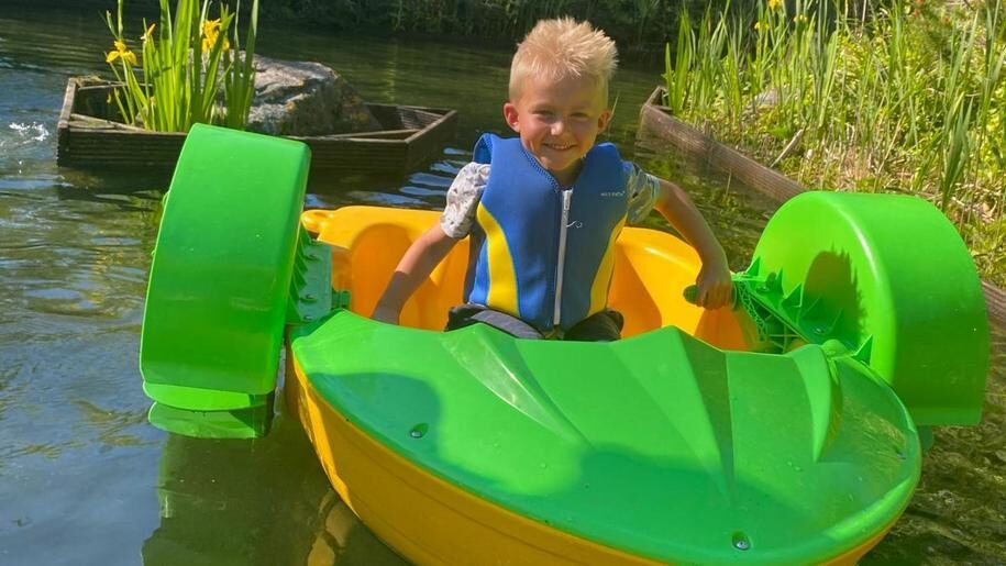 Bright green paddle boat and boy