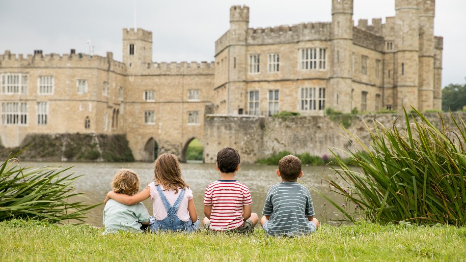 Leeds Castle - four children sitting on grass looking at the castle