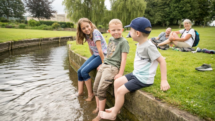 Leeds Castle - three children sitting on wall of river