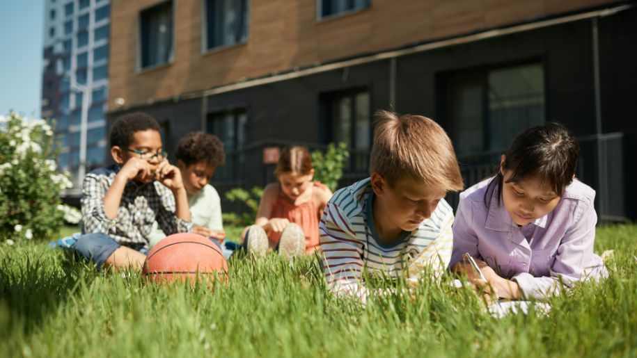 kids outside sitting on grass