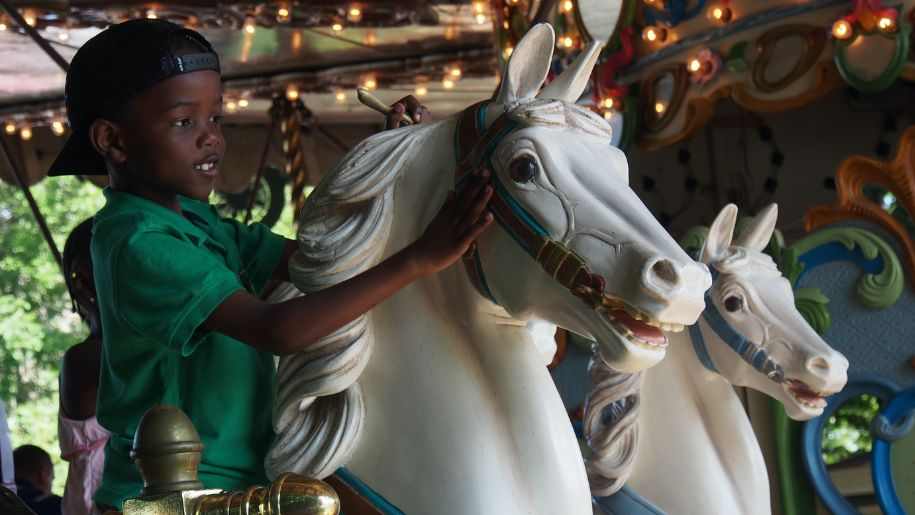 oy at fair carnival on horse