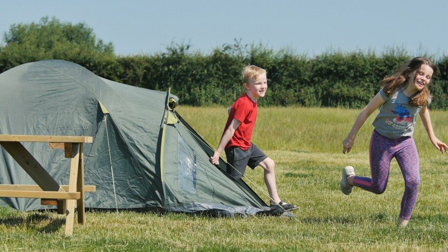 child coming out of tent at Lower Drayton Farm