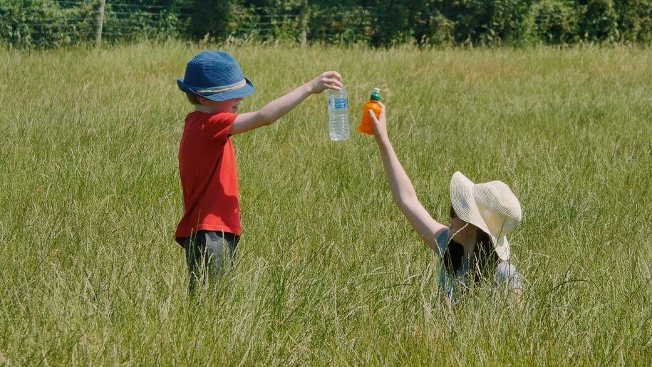 children holding drinks bottles in a field at Lower Drayton Farm