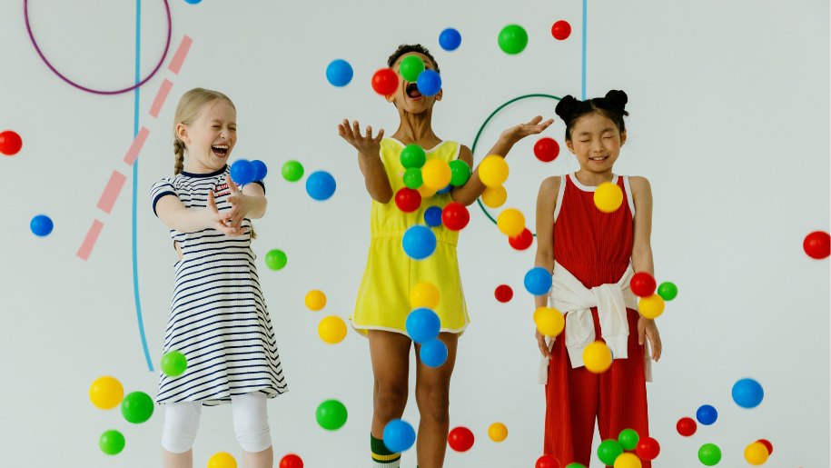 three girls playing with coloured balls
