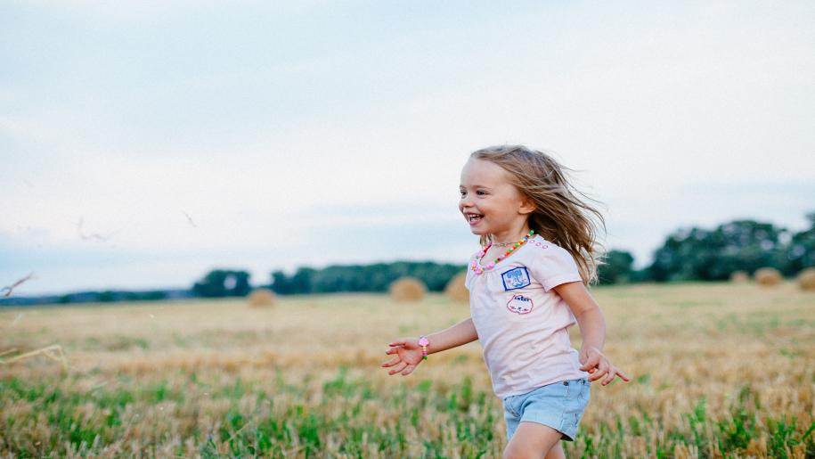 Child running through a field.