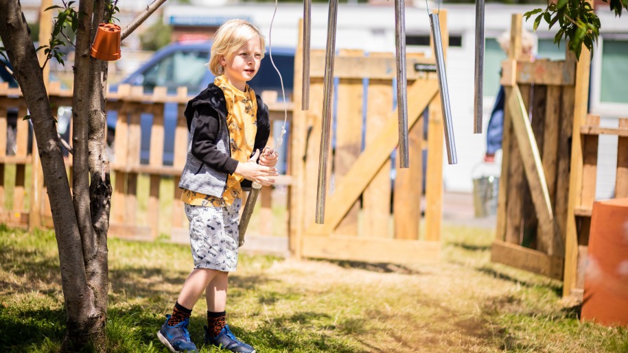 child with hanging chimes at Abundance play space