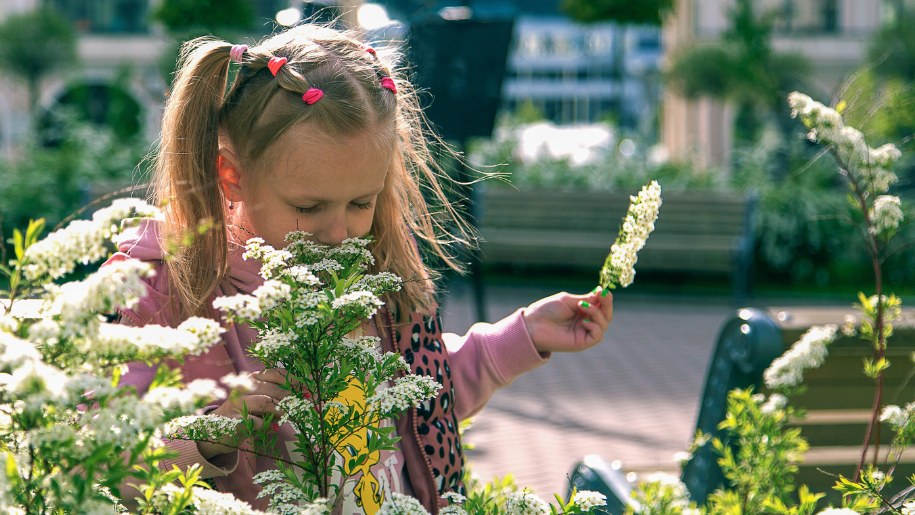Girl smelling flowers - family days out this september