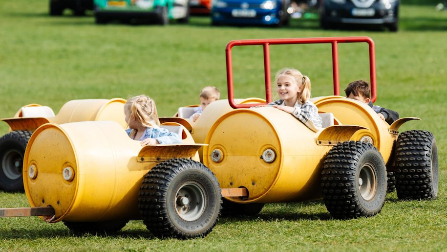 Children riding yellow barrel train